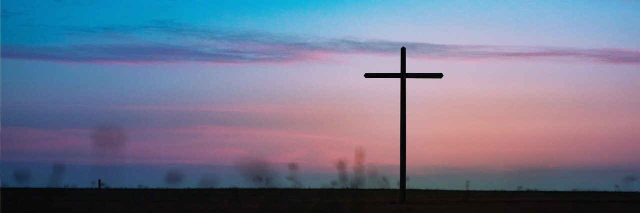 A cross with the sunset in the background A cross with the sunset in the background